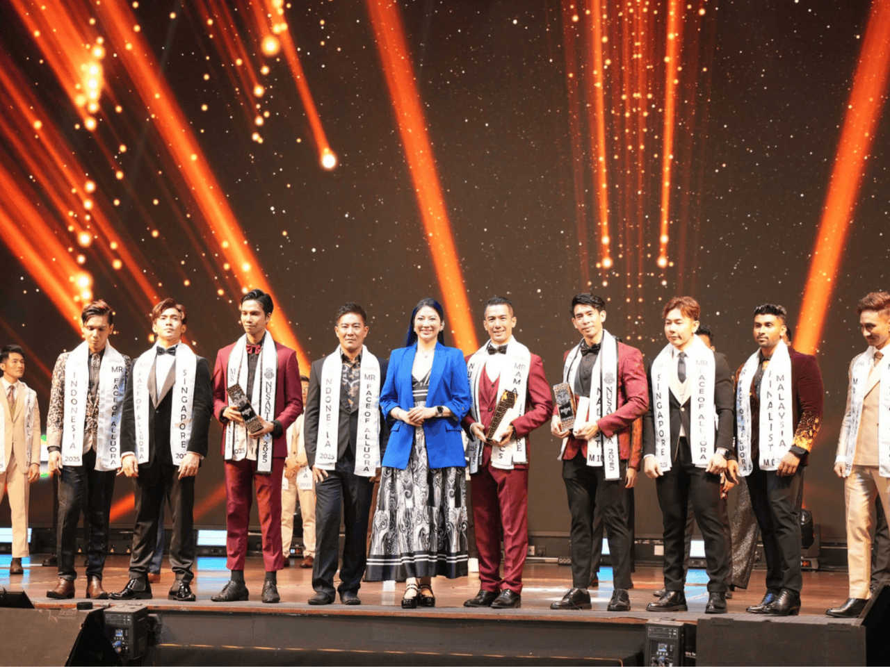 Fashion contestants on stage during a beauty pageant with sparkling lights in the background.